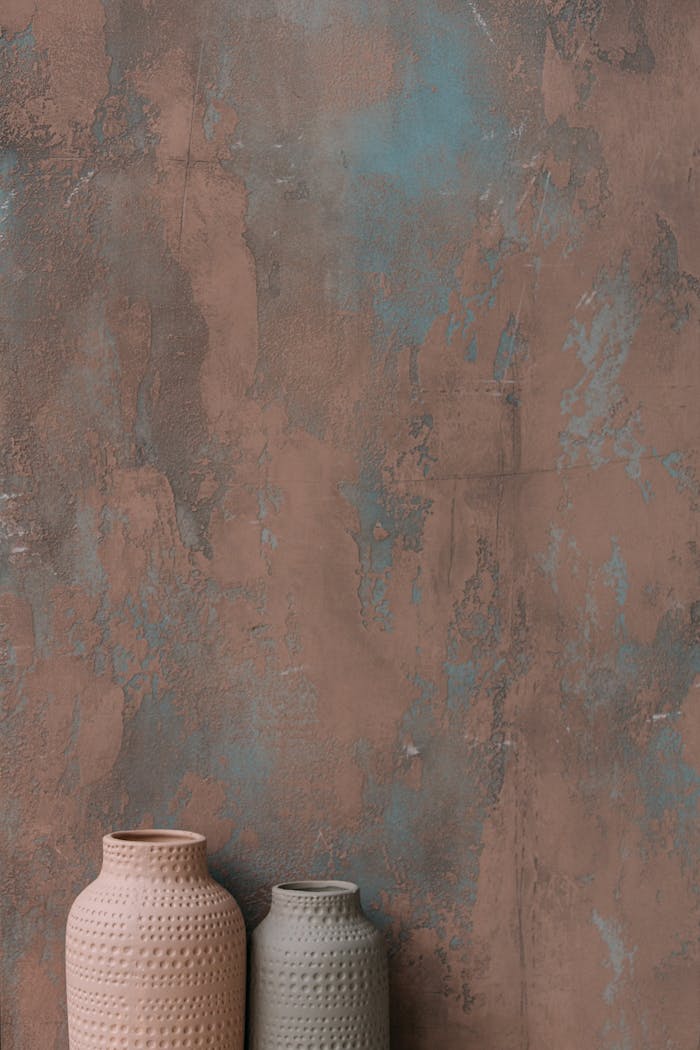 why-choose-us Minimalistic pottery vases placed against an artistic, textured wall with brown and blue shades.